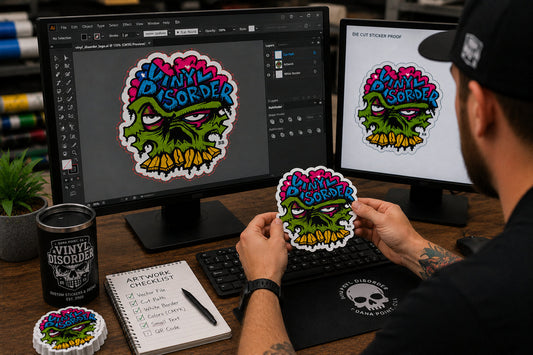 Designer reviewing undistorted Vinyl Disorder vector artwork on a monitor beside a finished sticker proof
