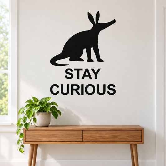 Black wall quote decal with aardvark silhouette and text "STAY CURIOUS"