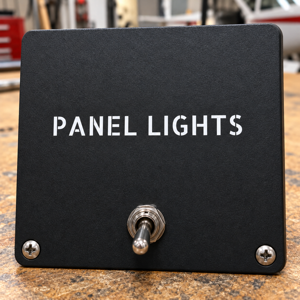 Matte black panel lights label plate with metal push-button and two mounting screws