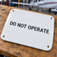 Aircraft safety stencil label: 'DO NOT OPERATE' on white plate with 4 mounting holes
