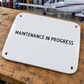 White maintenance in progress label with four mounting holes, stencil aircraft text