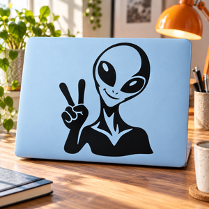 Peace-sign alien vinyl decal sticker, black graphic on light blue laptop lid