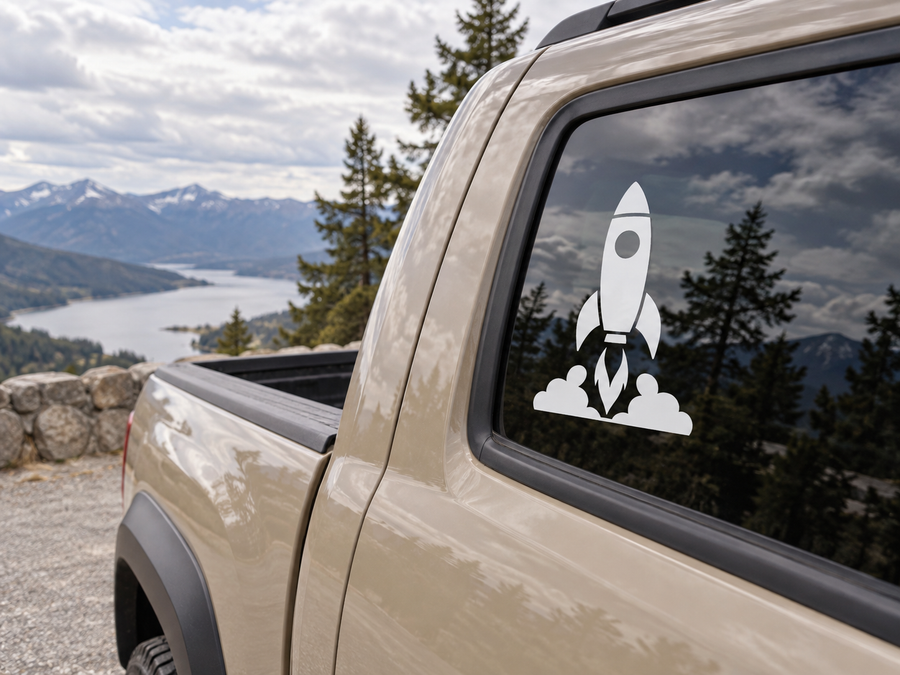 White rocket ship and flame vinyl decal on car window.
