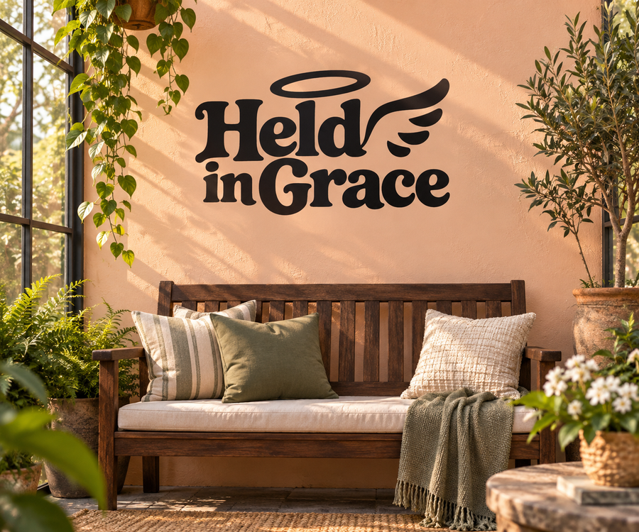 Wall vinyl decal with bold script 'Held in Grace' and angel wings