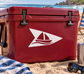 Vinyl decal of white sailboat logo on red surface