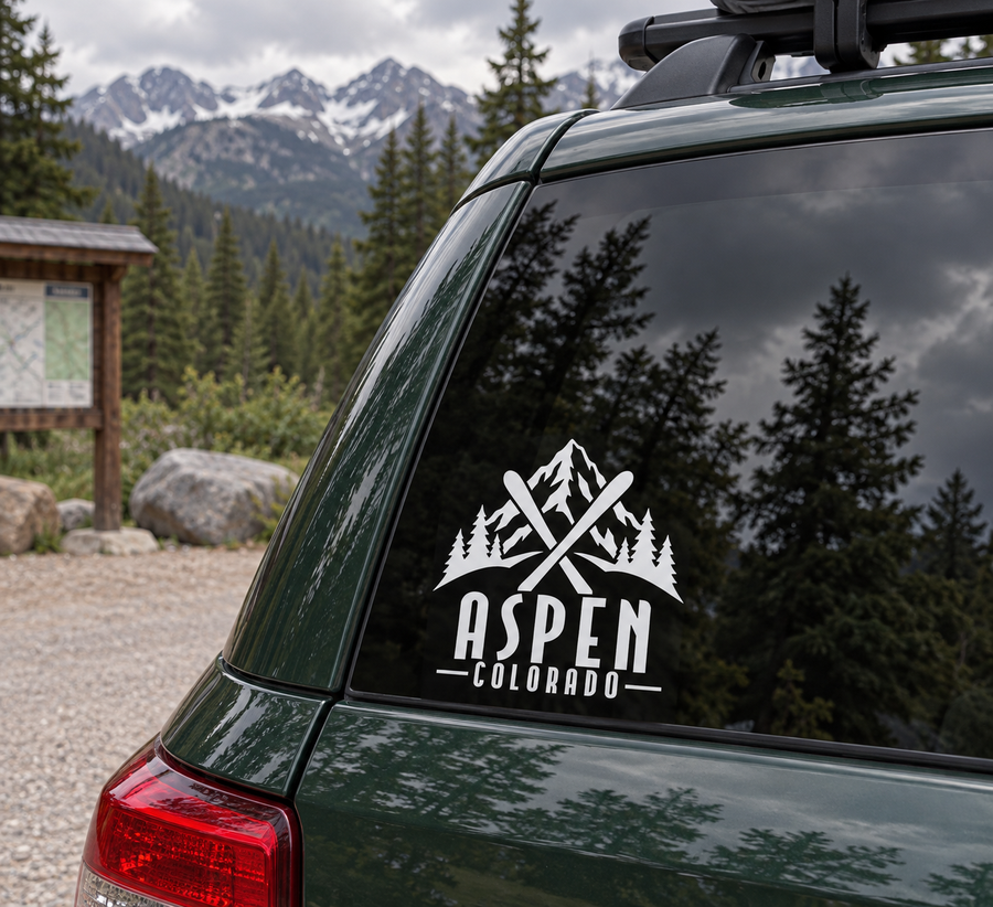 Aspen crossed skis wordmark vinyl decal in white on dark green car window