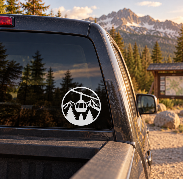 Round gondola mountain crest vinyl decal on vehicle window, white and black