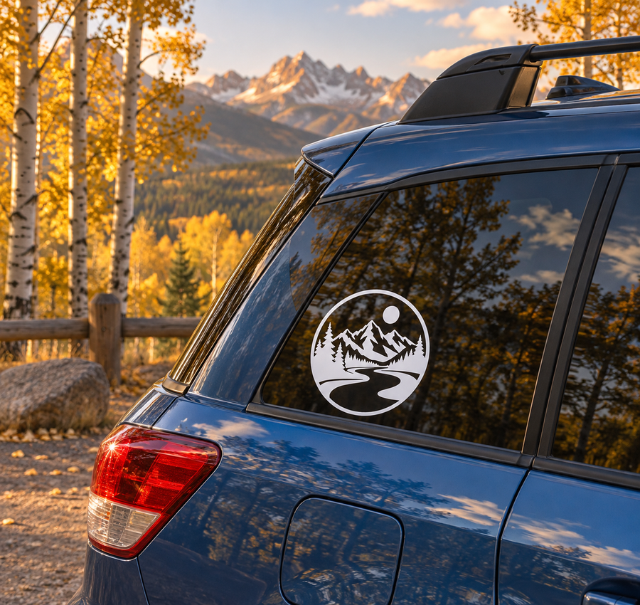 Circular vinyl decal with black-and-white mountain, pine trees, river, and sun
