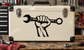 Cream tool case with top handle, corner latches, and black wrench-and-dog logo
