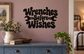 Black “Wrenches Before Wishes” wall decal lettering with wrench icon accents