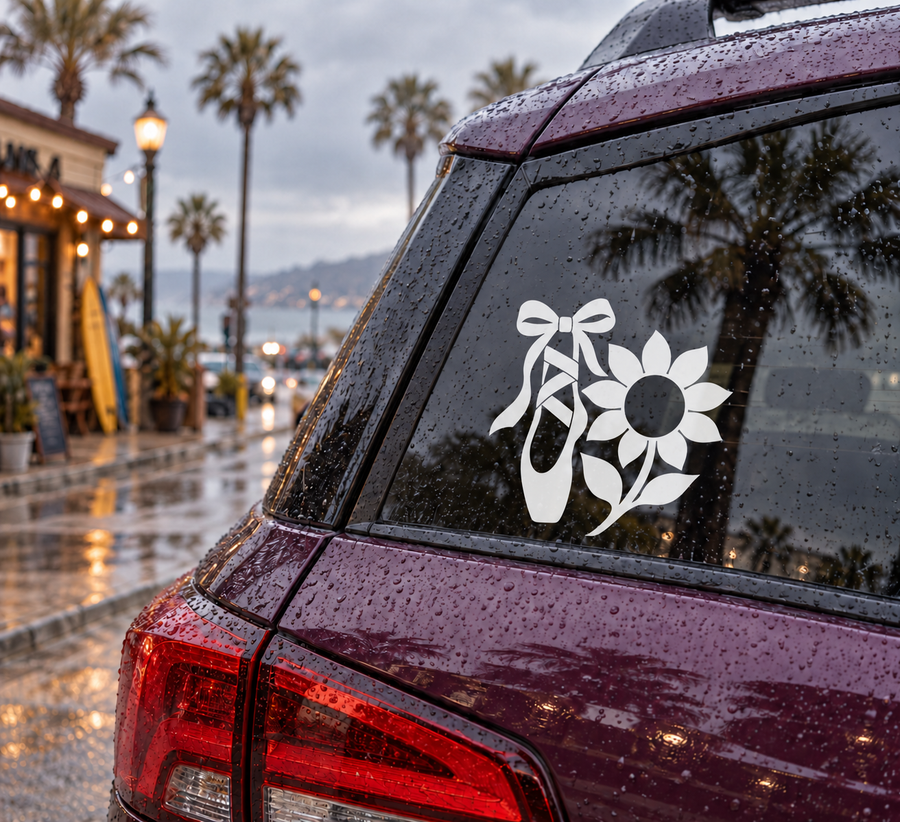 Vinyl decal of white ballet pointe shoes and sunflower on dark car window
