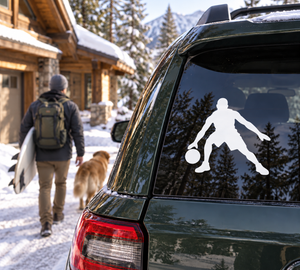 Basketball vinyl decal of a player dribbling, mounted on car window, white silhouette