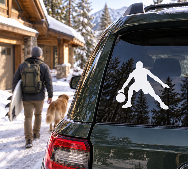 Basketball vinyl decal of a player dribbling, mounted on car window, white silhouette