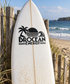 White surfboard with black BROCEAN ENERGY vinyl decal and palm tree, sun, and waves
