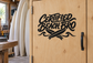 Certified Beach Bro vinyl decal on wood door, black logo text and surfboard graphic