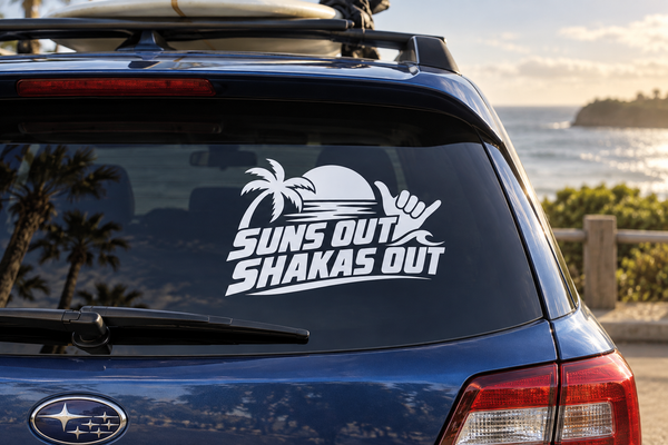 Car rear window vinyl decal with "SUNS OUT SHAKAS OUT" text and palm tree icon