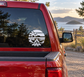 Circular beach campfire vinyl decal with palm tree, flames, and sunset stripes on car glass