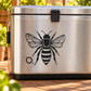 Stainless steel container with black honeybee decal and orbit dot halo