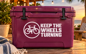 Vinyl decal with bike icon and "KEEP THE WHEELS TURNING" text on maroon