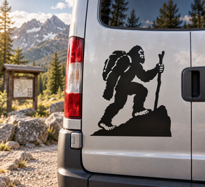 Black Bigfoot vinyl decal on vehicle door, kneeling with backpack and raised hand