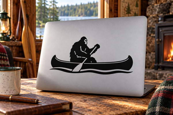 Bigfoot paddling canoe vinyl decal on laptop