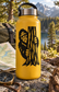 Vinyl Bigfoot decal on yellow bottle, bearded face and pine-trunk texture