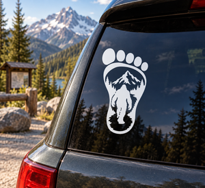 Bigfoot footprint vinyl decal with white paw, Bigfoot silhouette, and mountain trees