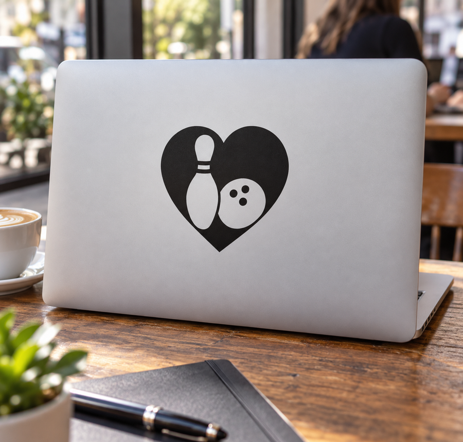 Heart-shaped bowling pin and ball vinyl decal on light-colored laptop
