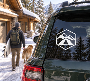 Alpine tent crest vinyl decal on car window, white hex emblem with mountains and tent