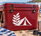 White fern frond and tent arc vinyl decal on a red surface