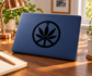 Vinyl decal with black circular cannabis leaf peace symbol on a blue laptop lid