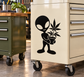 Alien botanist vinyl decal: black alien holding cannabis leaf bouquet on light surface.