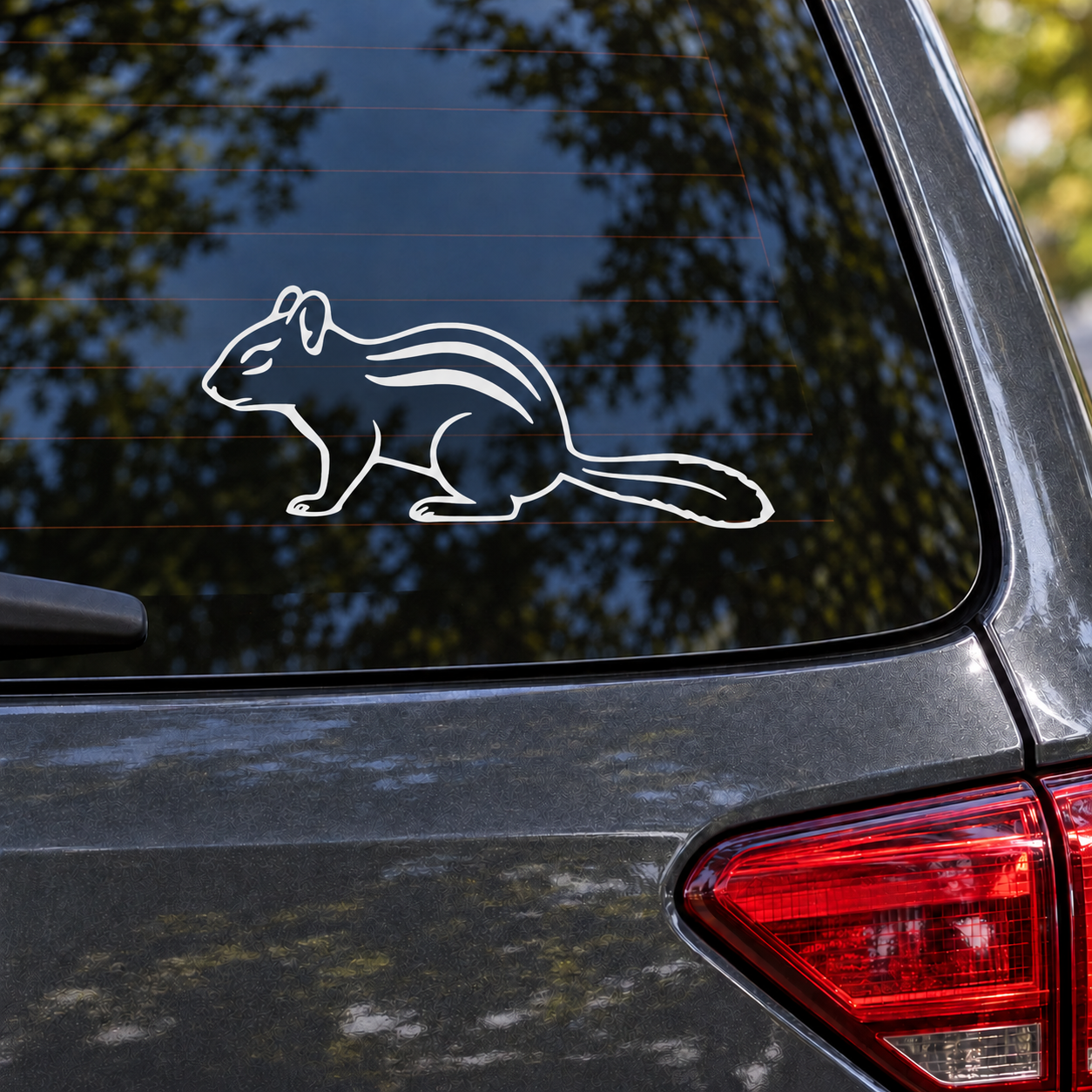 Striped chipmunk vinyl decal with sweeping tail outline on car window