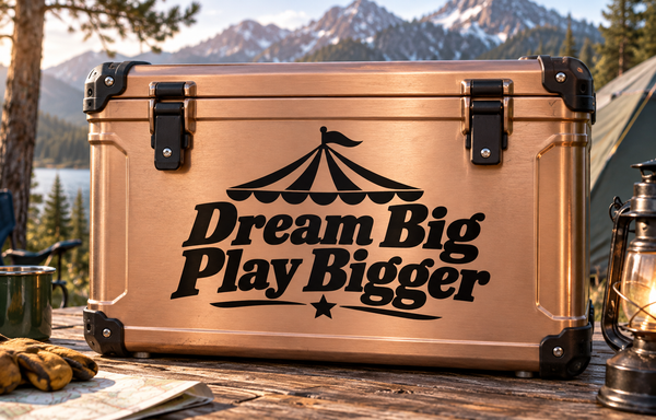 Bronze vinyl decal suitcase with black “Dream Big Play Bigger” text and circus tent icon