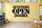 Classroom vinyl wall decal text: "QUESTIONS OPEN DOORS" in bold black letters.