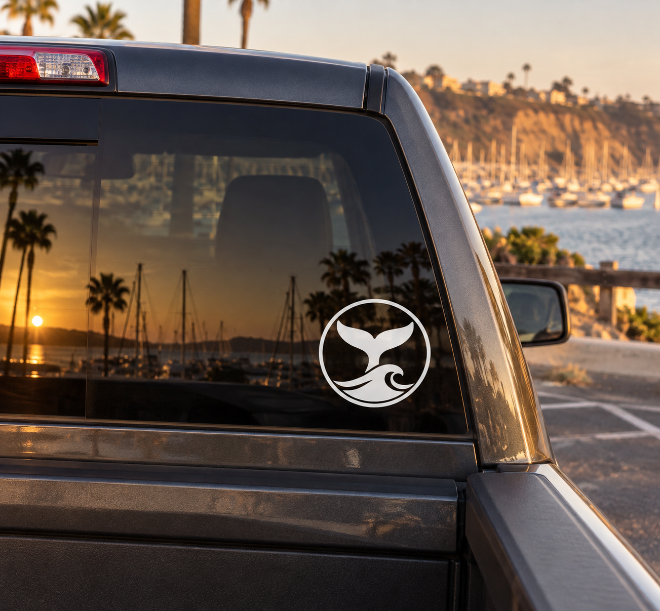Whale tail vinyl decal with black logo in a white circle on car window