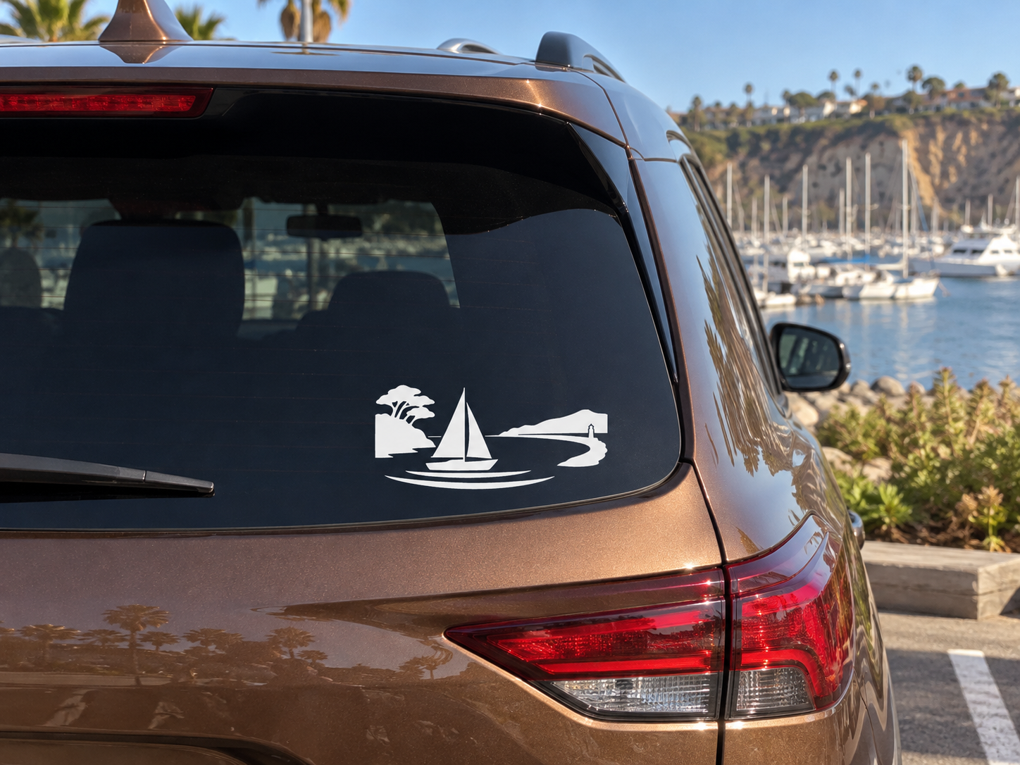 White vinyl sailboat and harbor horizon decal on car rear window