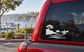 Coastal headlands vinyl decal with tree silhouette, sailboat, cliffs, and wave lines on a car