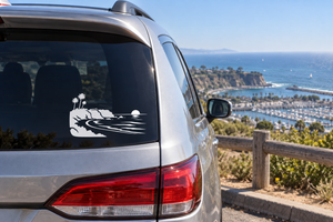 Vinyl car window decal with black coastal headlands, ocean waves, and palm trees