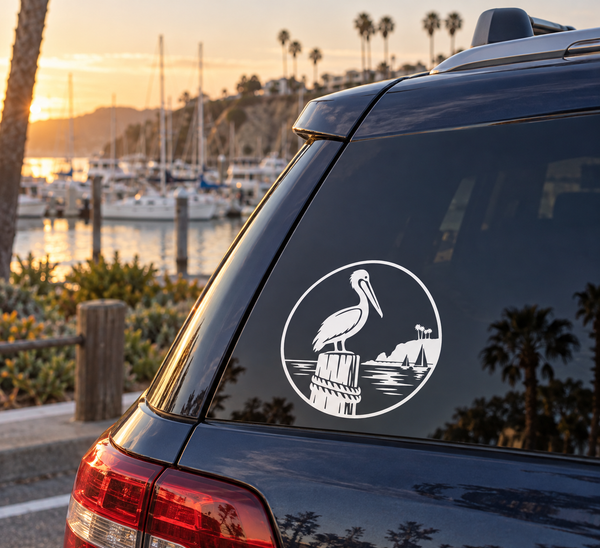 Round black-and-white vinyl decal with pelican crest on a car window