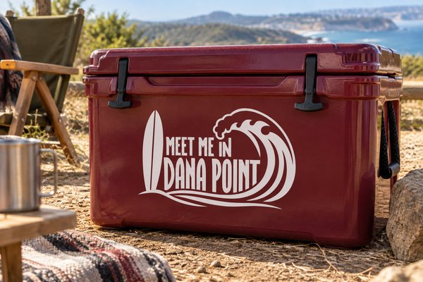 Vinyl decal with “MEET ME IN DANA POINT” lettering and surfboard wave icon on a cooler