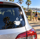 White vinyl decal of coffee mug with flames and dart on car rear window.