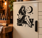 Black vinyl decal of devil woman sitting on a piano bench with moon and stars