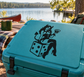 Teal surface with black vinyl decal of a devilish jester holding cards and dice