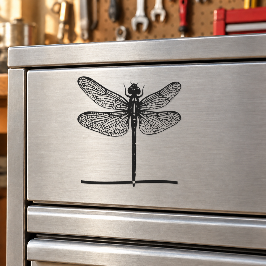 Black dragonfly vinyl decal with mirrored wings and long body on a horizontal line
