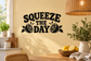 Black vinyl wall decal reading 'SQUEEZE THE DAY' with lemon slice graphics