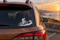 White vinyl e-bike rider decal on car window, cyclist silhouette on uphill trail.