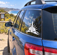 White obelisk vinyl decal on car rear side window, sunburst rays and curved base