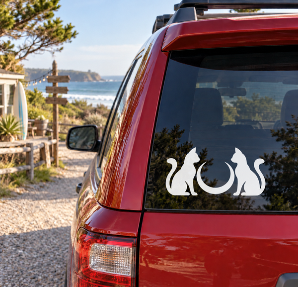 White cat silhouettes with crescent moon vinyl decal on a car rear window