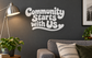 White vinyl wall decal reading 'Community Starts with Us'